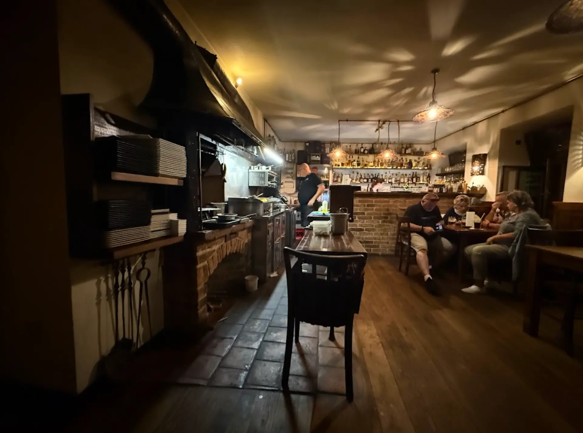 Interiér restaurace UDÍRNA s otevřenou kuchyní a barem